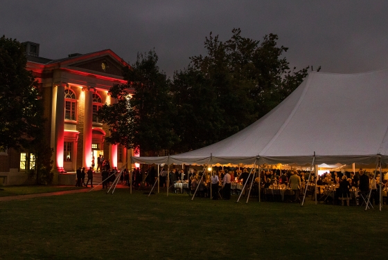 Ne Ultra Event with people under outdoor dining tent and wall lit up in red