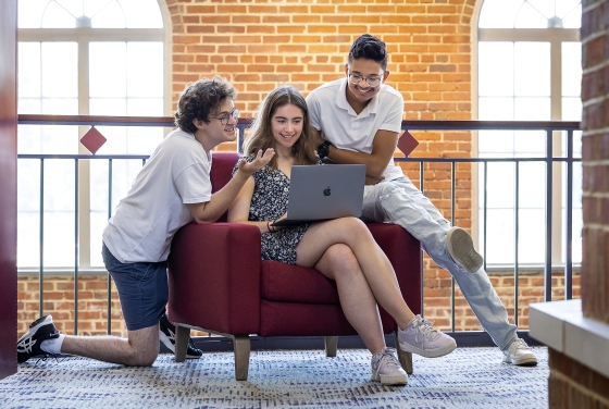 Group of students around laptop