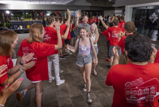 student and family walking through welcome tunnel during Orientation