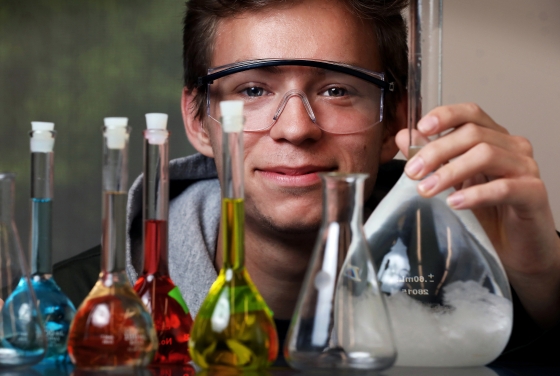 Student holding up beakers of various colors