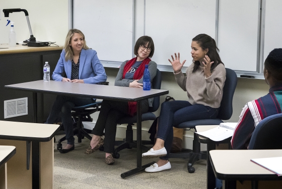 three women speaking at a table