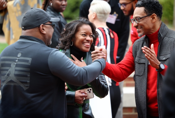 BSC celebration three people smiling and greeting each other