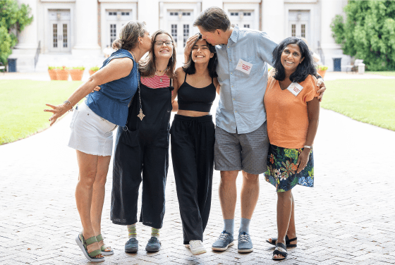 Parents and their students embracing outside and smiling