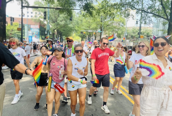 a group of people walking in a street while wearing rainbow colors