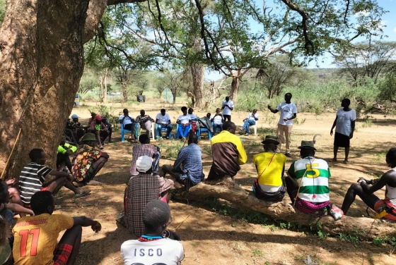 a group of people sitting together in the outdoors