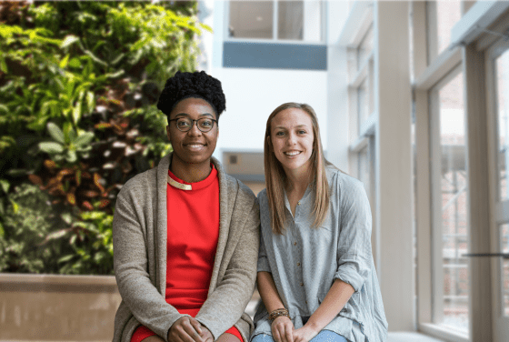 a young Black woman and a young white woman sit together