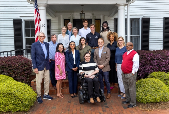 a group of alumni in front of a white house on Davidson College's campus
