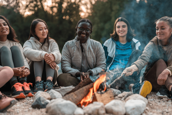Students smiling around campfire