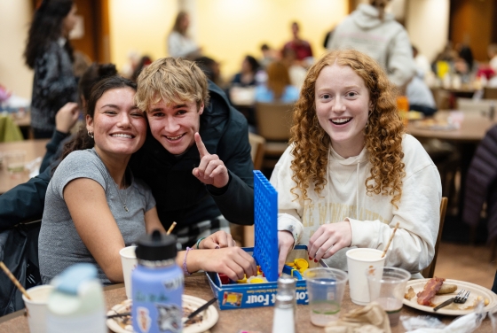 Three students play Connect Four