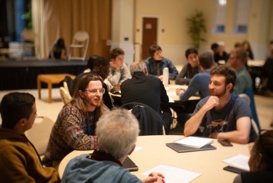 A forum where students are talking around tables