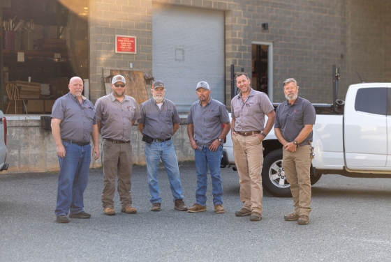 Physical Plant Staff outside building in front of truck