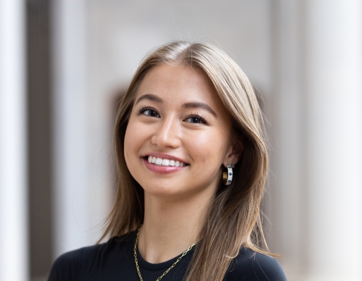 a young Asian American woman wearing a black top and smiling