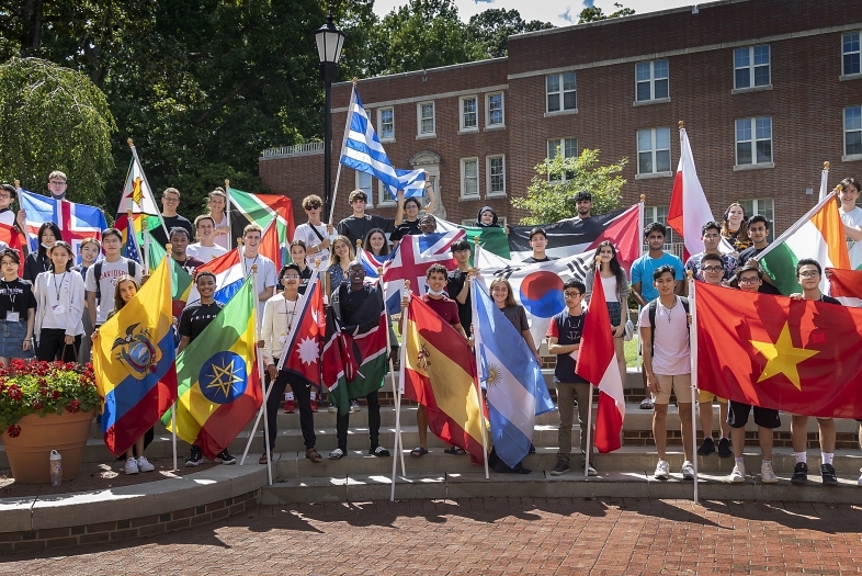 group of international students hold country flags on Alvarez Union steps