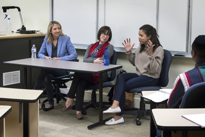 three women speaking at a table
