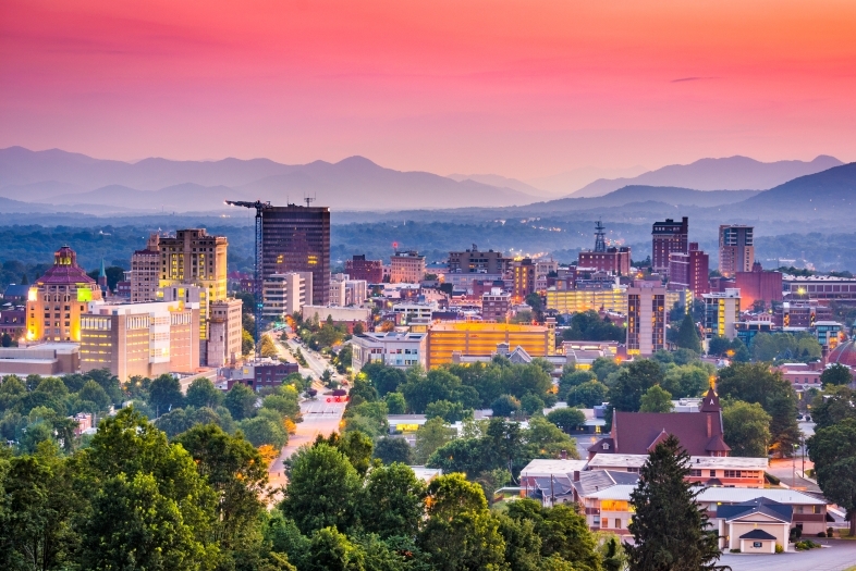 Asheville, NC skyline with mountains and sunset in background
