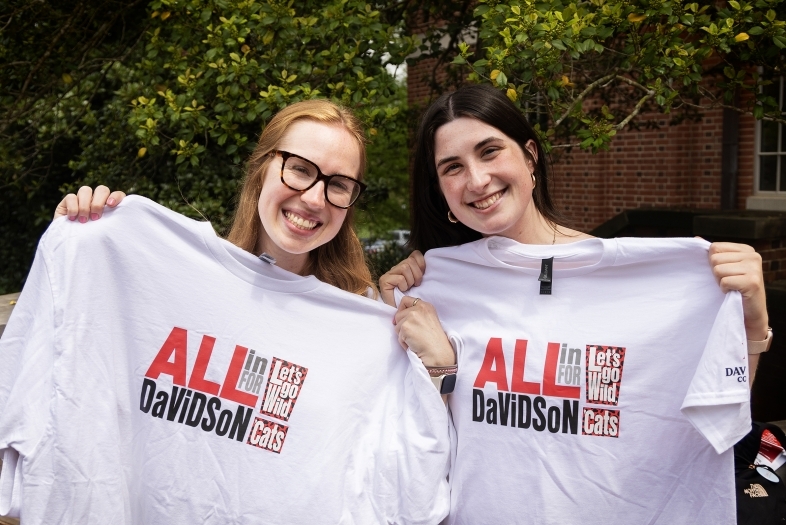 two young women holding white tee shirts