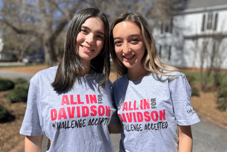 two students wearing ALL IN FOR DAVIDSON t-shirts