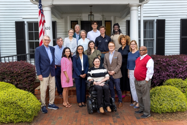 a group of alumni in front of a white house on Davidson College's campus