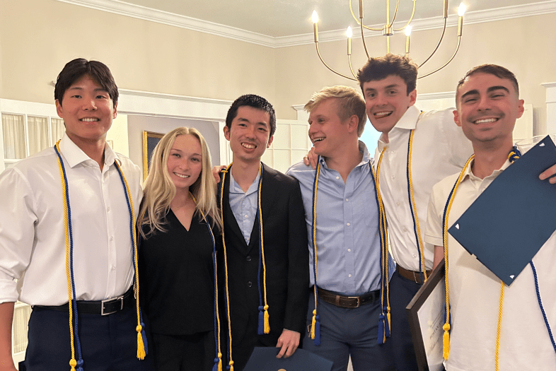 a group of young people smiling holding awards
