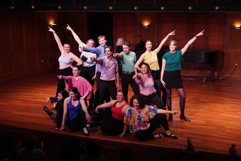 a group of young people smile and pose on a stage