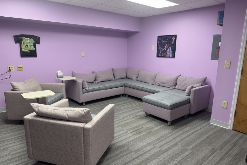 a purple painted room with comfy couches and chairs