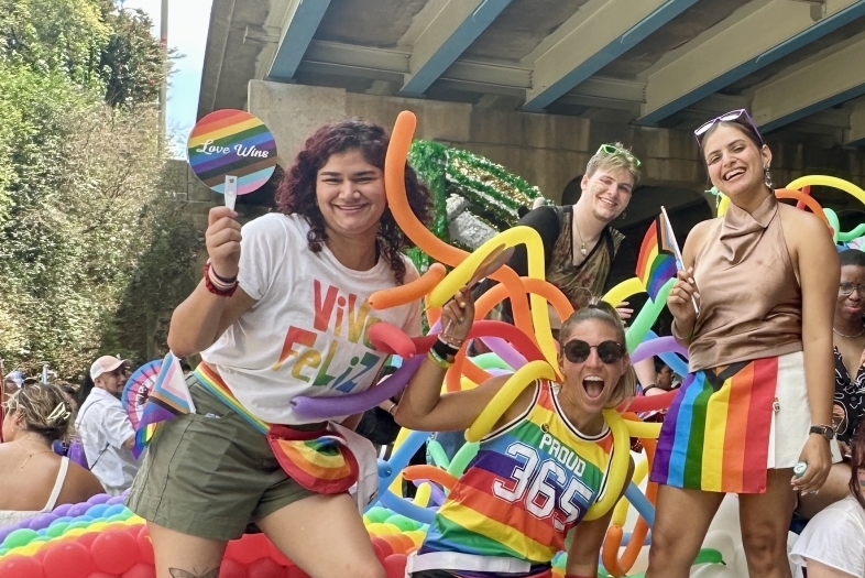 a group of young people on a Pride float on a sunny day