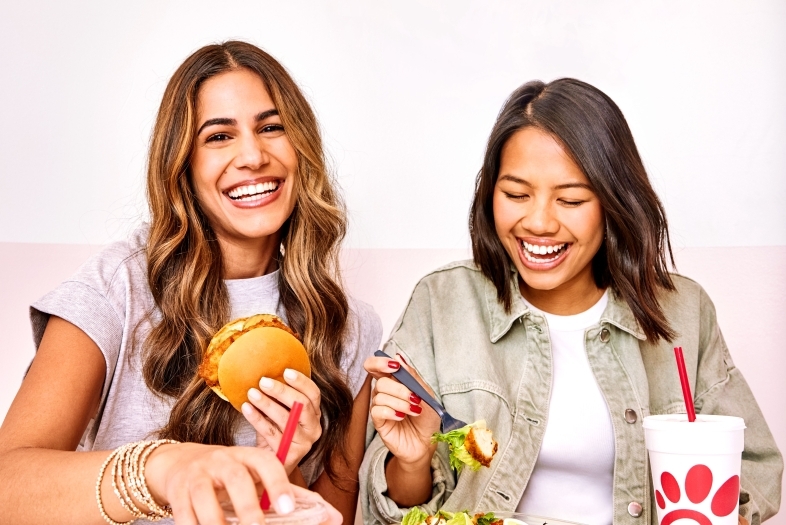 two women eating sandwiches and salads from chick-fil-a
