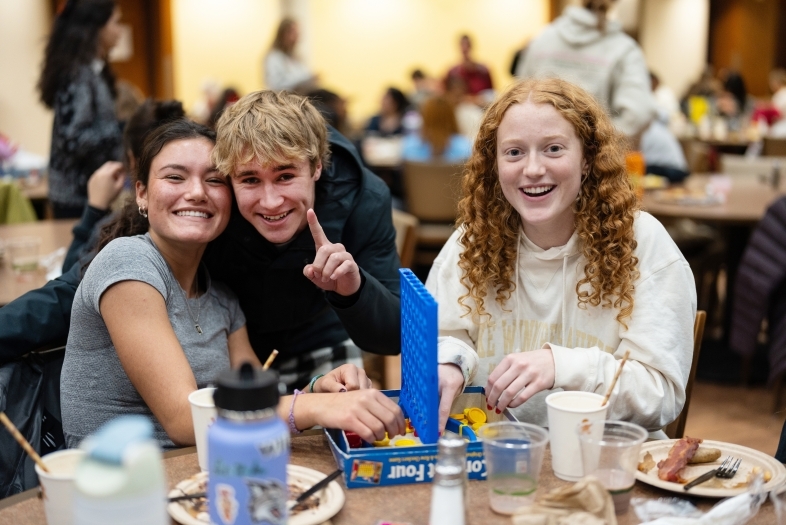Three students play Connect Four