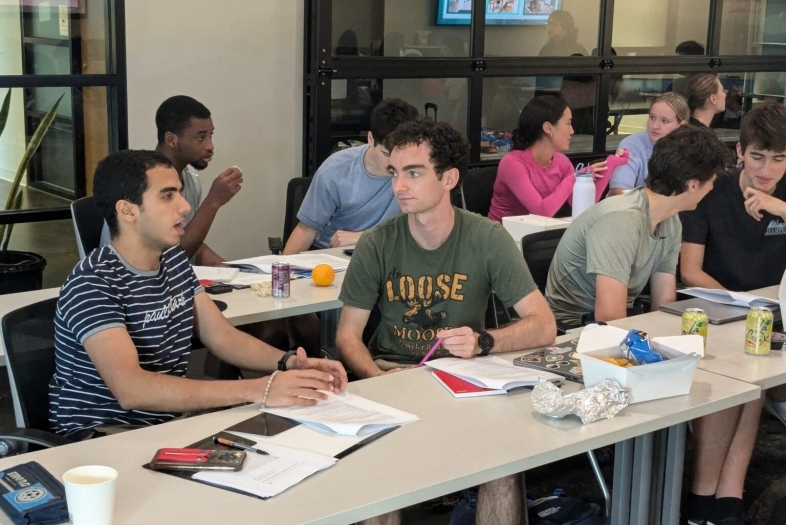 Students at a long table in a DCI Training session