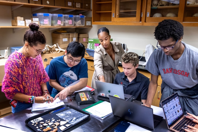 Brittany Brown and students doing research in archeology lab