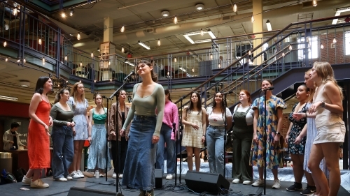 a group of young women perform on stage with twinkly lights