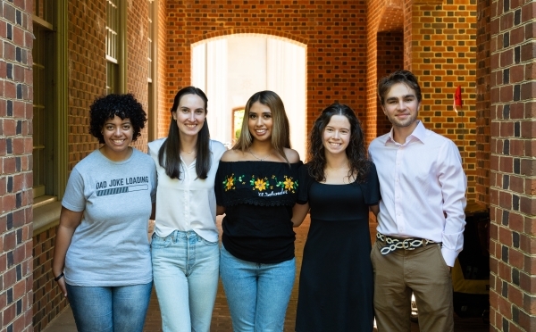 a group of young people standing together in a brick hallway