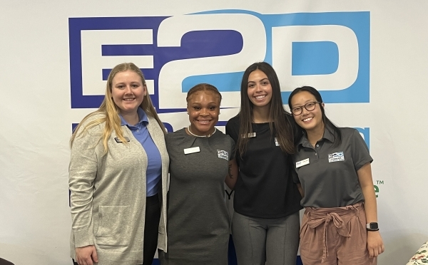 a group of young women standing in front of a wall that reads "E2D"