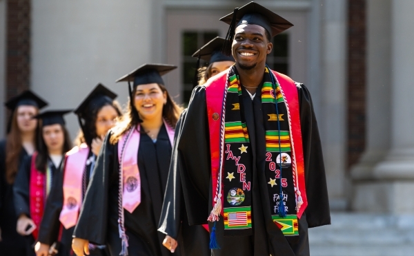 Commencement 2025 students smiling in procession 