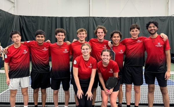 a group of pickleball players on an indoor court wearing red uniforms