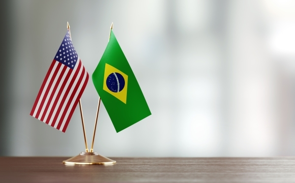 two small flags from the US and Brazil on a desk