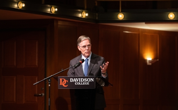 a man speaks into a podium in an auditorium 