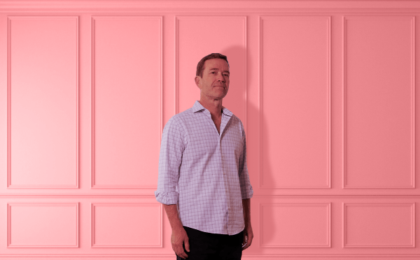 Man standing against pink wainscoting
