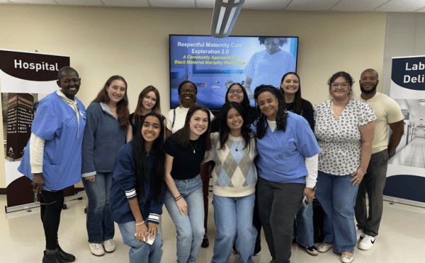 a group of students and adults in scrubs standing together and smiling