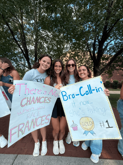 Students holding handmade signs cheering at the Cake Race