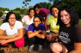 Students take a break from tending to the community garden to gather for a photo