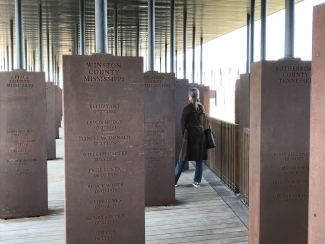 Student stands amidst monument blocks reflecting