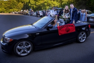 Caroline and Tyler with car lineup behind them 