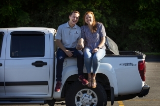 Two friends sitting on trunk of truck 
