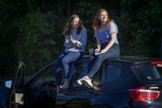 Two friends on top of car 