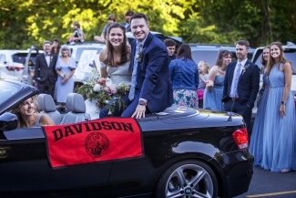 Caroline and Tyler smiling with Davidson flag 