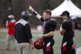 Football Players talk to Coach Abel