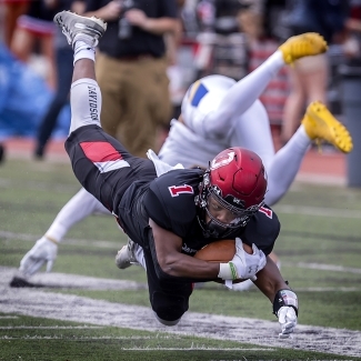 Davidson Football Player Holds Football while Avoiding Tackle