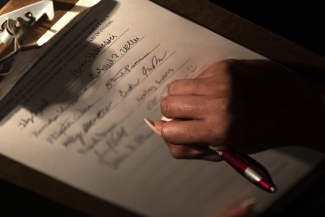 Honor code signing where hand is signing the pledge