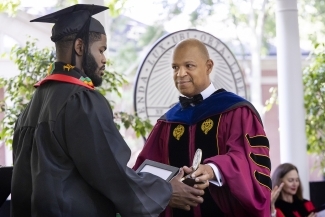 student receiving award from Dean McCrae at Commencement 2022